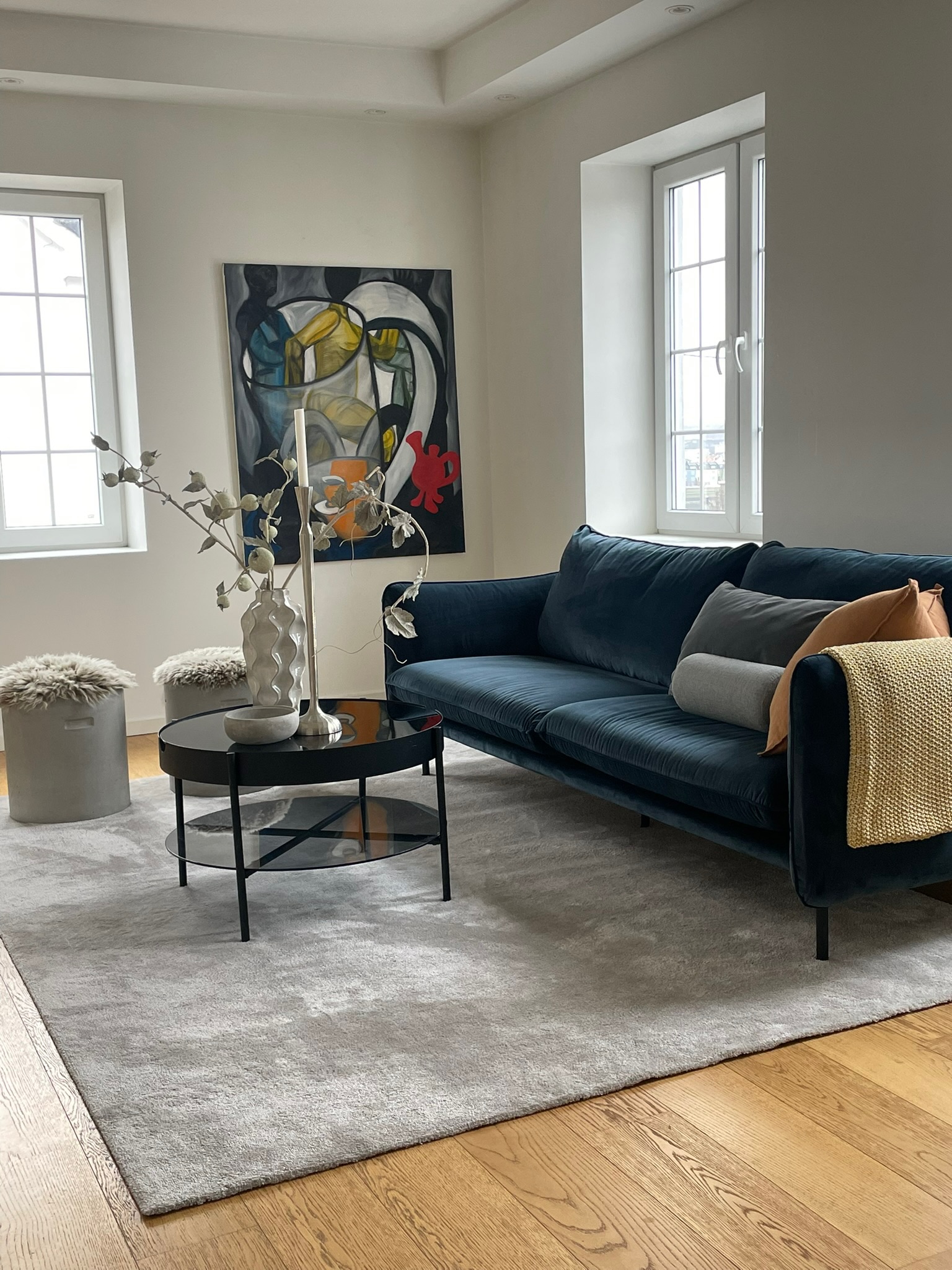 Boligstyling stue med blå velursofa, abstrakt kunst og fargerike aksenter