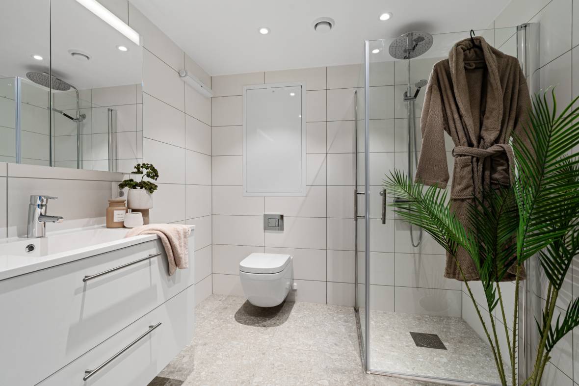 Moderne bad i nybygg stylet med badekåpe og spa-detaljer