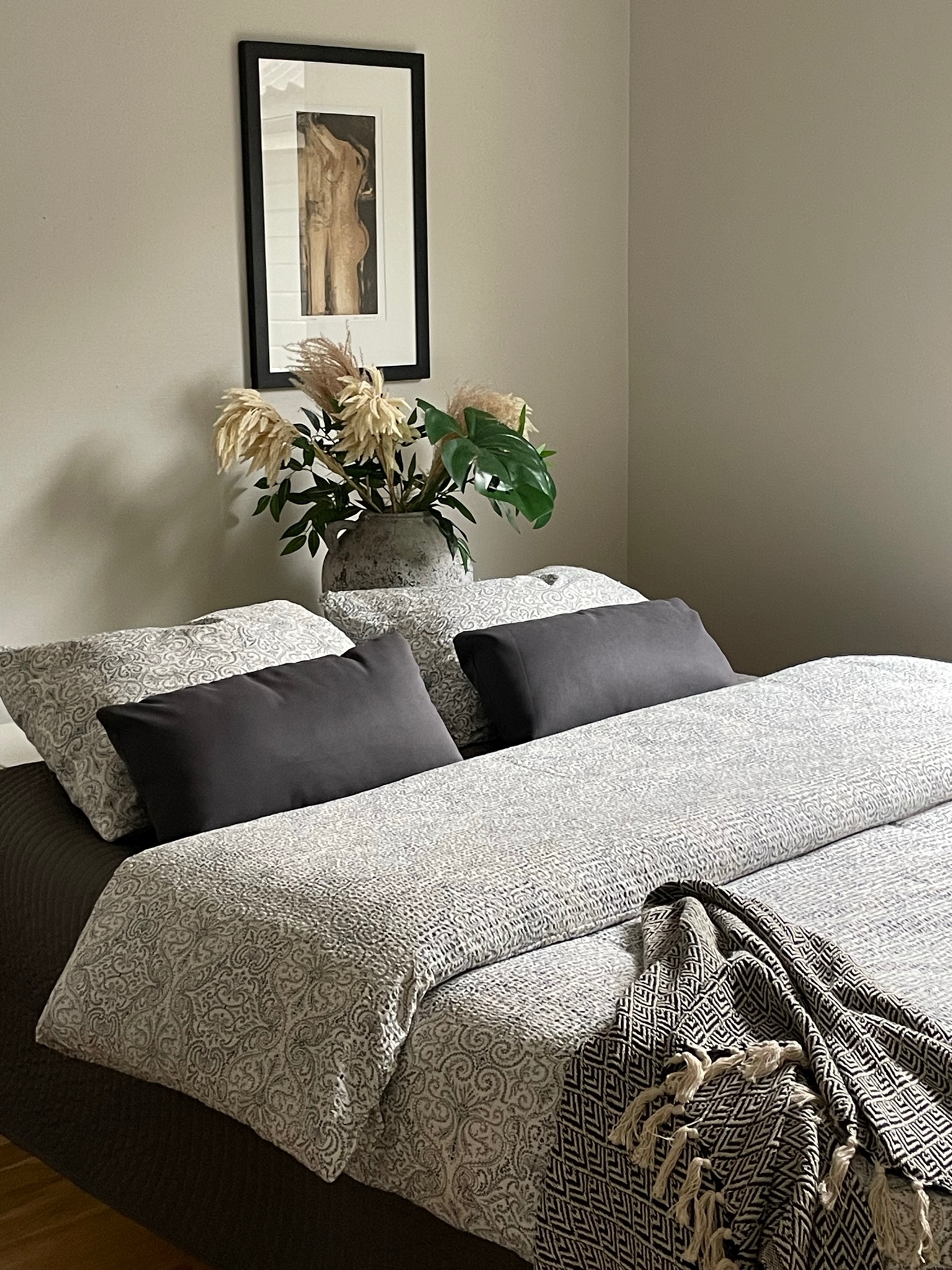 Stylet soverom med nøytrale farger og tekstiler